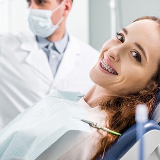 Woman with braces relaxing in orthodontist's treatment chair