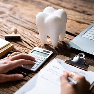 Patient using calculator while filling out invoice on desk