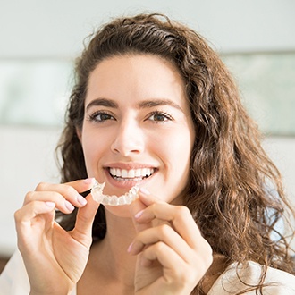 Woman placing an Invisalign tray