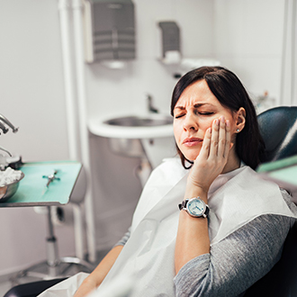 Patient with toothache sitting in dental treatment chair