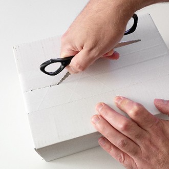Man using scissors to open packages