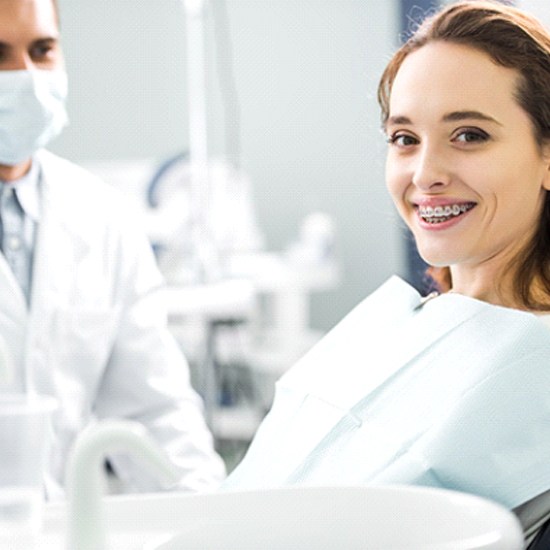 woman with braces smiling with orthodontist in Grafton