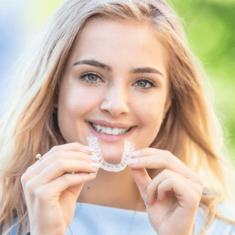 Woman placing Invisalign clear braces