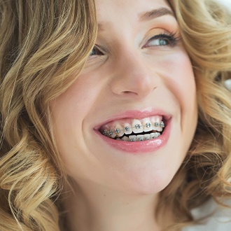 Woman with traditional braces smiling