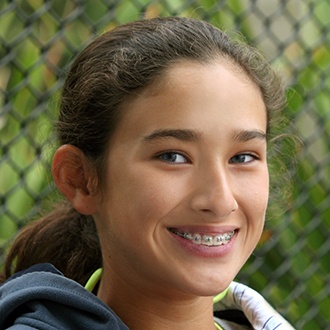 Teen girl with traditional braces smiling