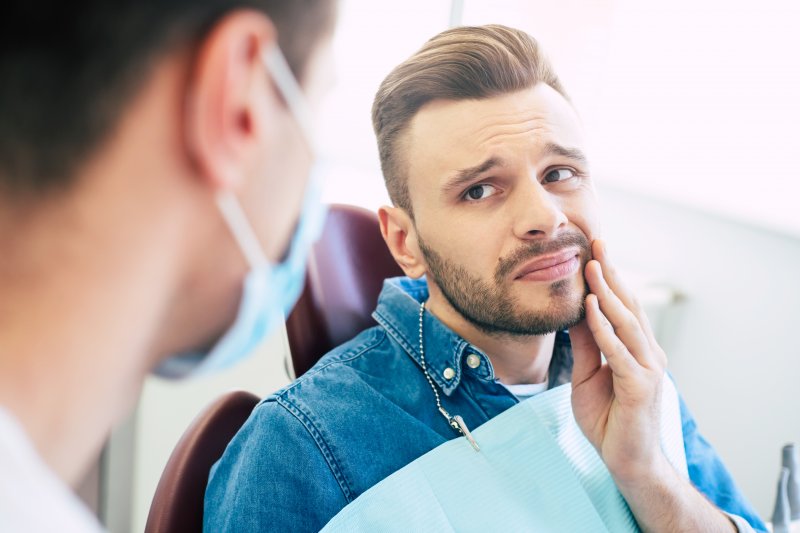 Man speaking to orthodontist about tooth pain