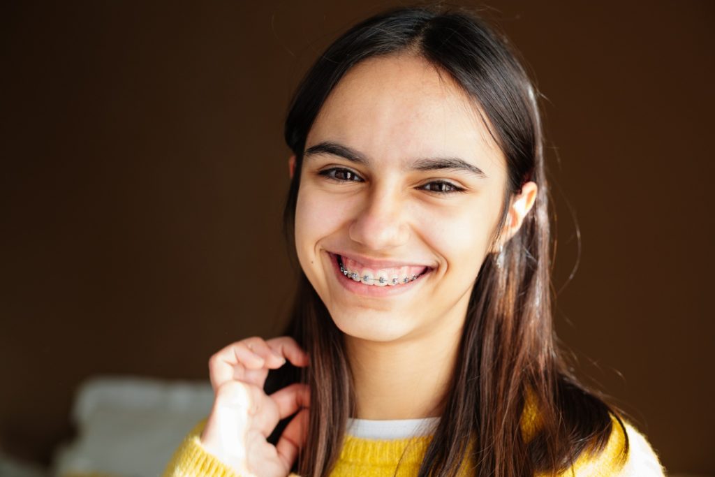 Closeup of young woman with braces smiling