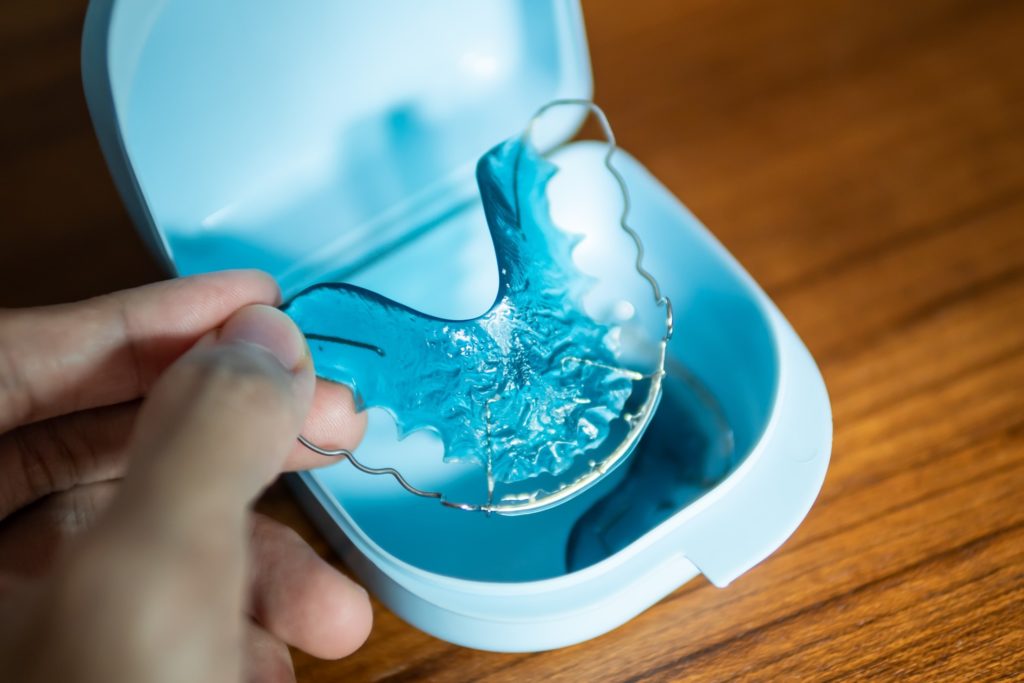 Patient holding blue retainer