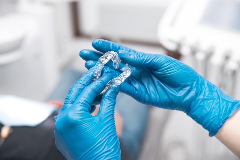 Dentist examining Invisalign aligners