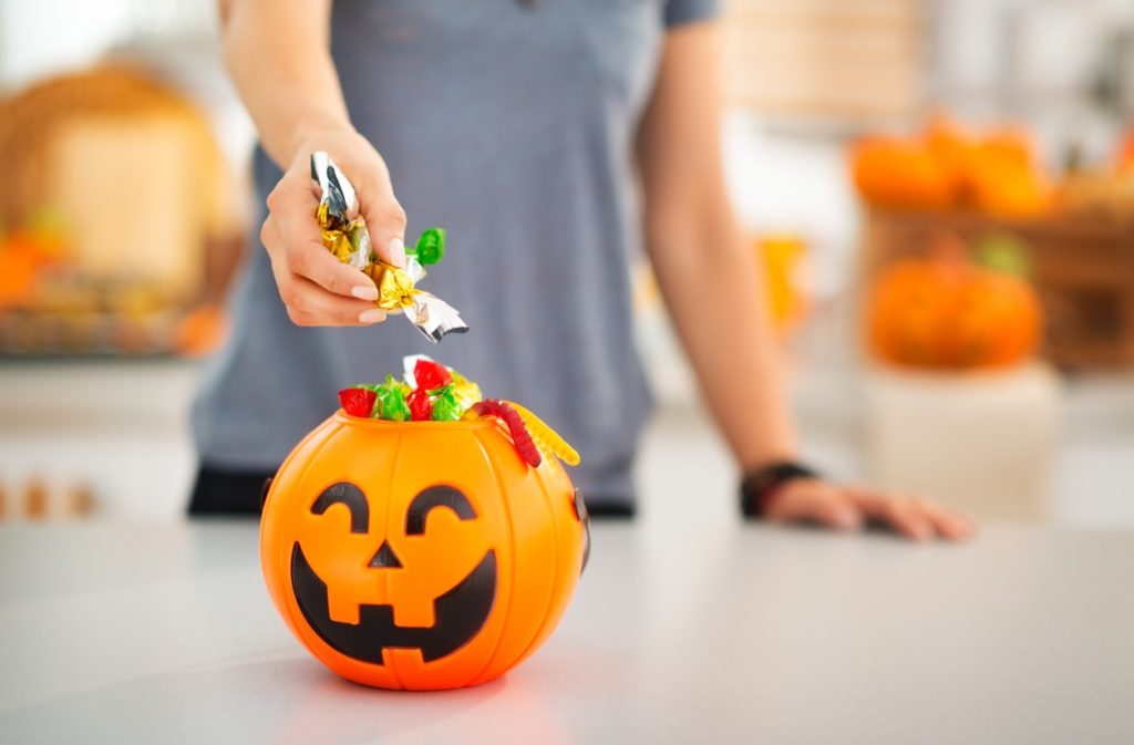 Woman filling up bowl with Halloween candy