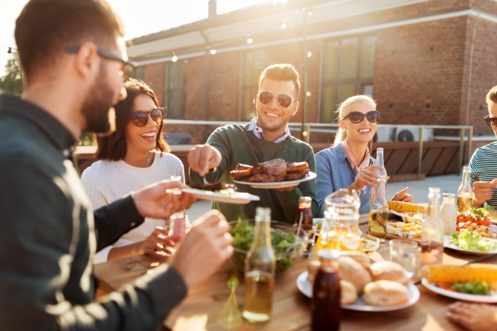 Group of friends smiling while enjoying Thanksgiving meal