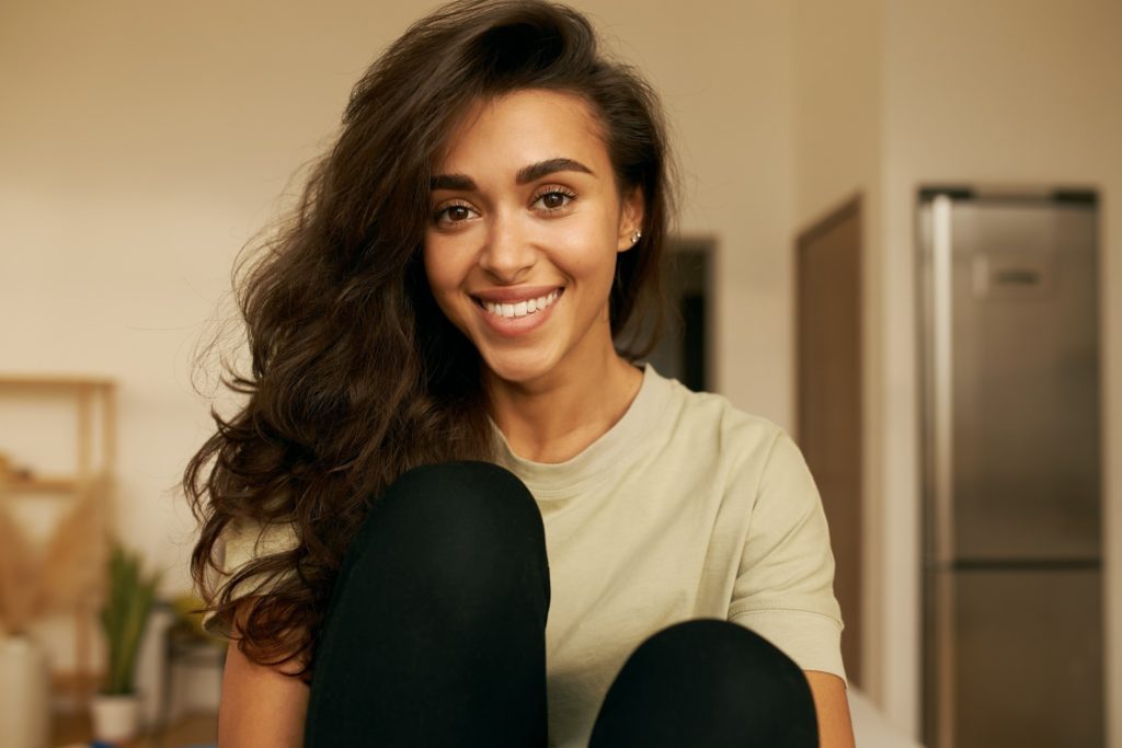 Woman with straight teeth smiling at home