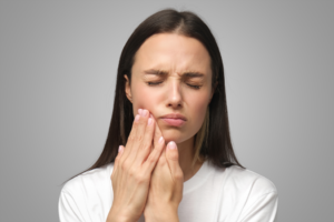 a person holding their jaw in pain