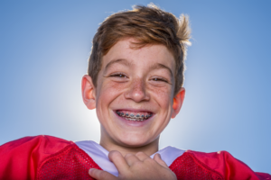 a teen with braces in a football jersey